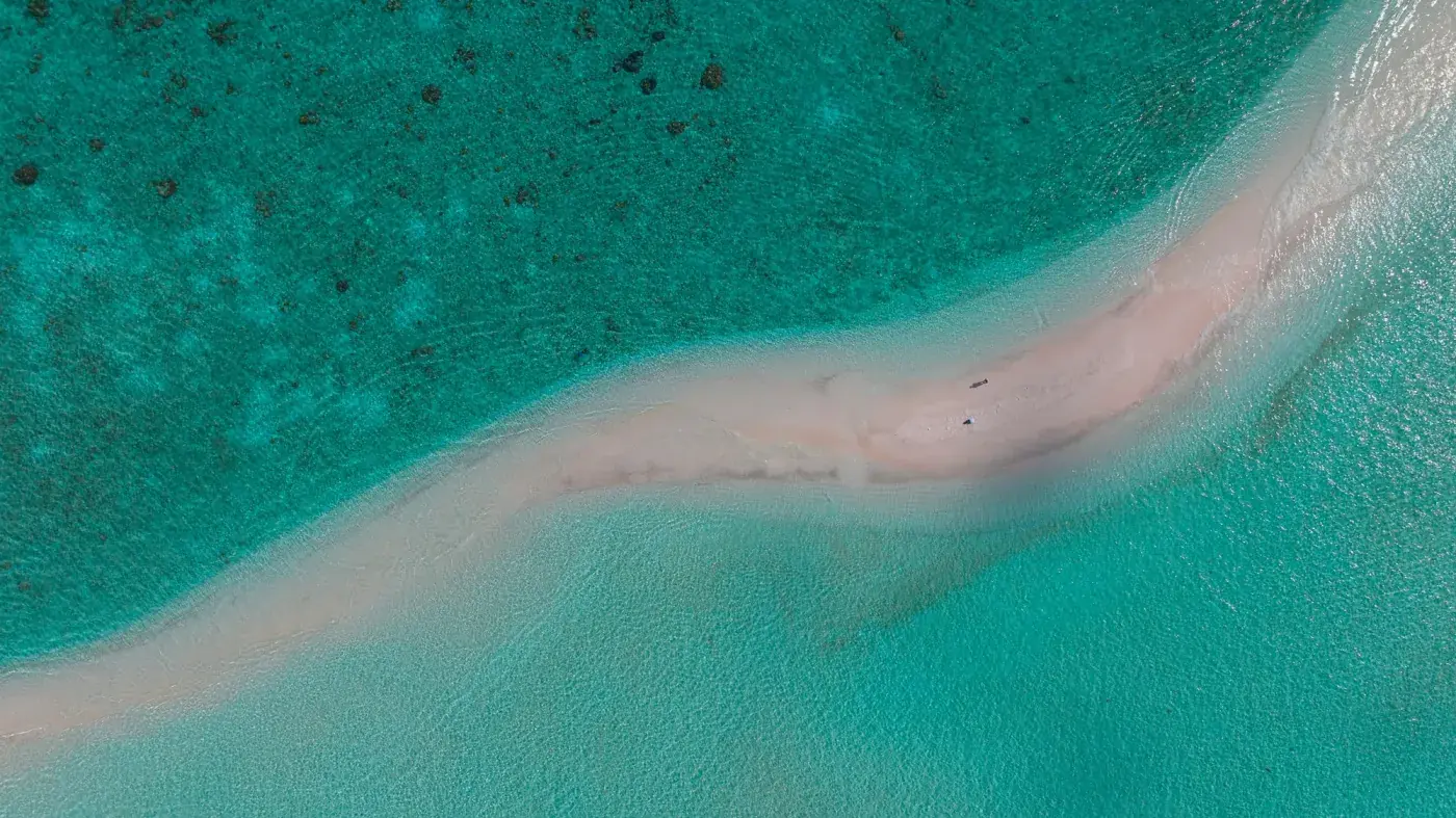 A sandbar snaking through shallow turquoise Bahamian water