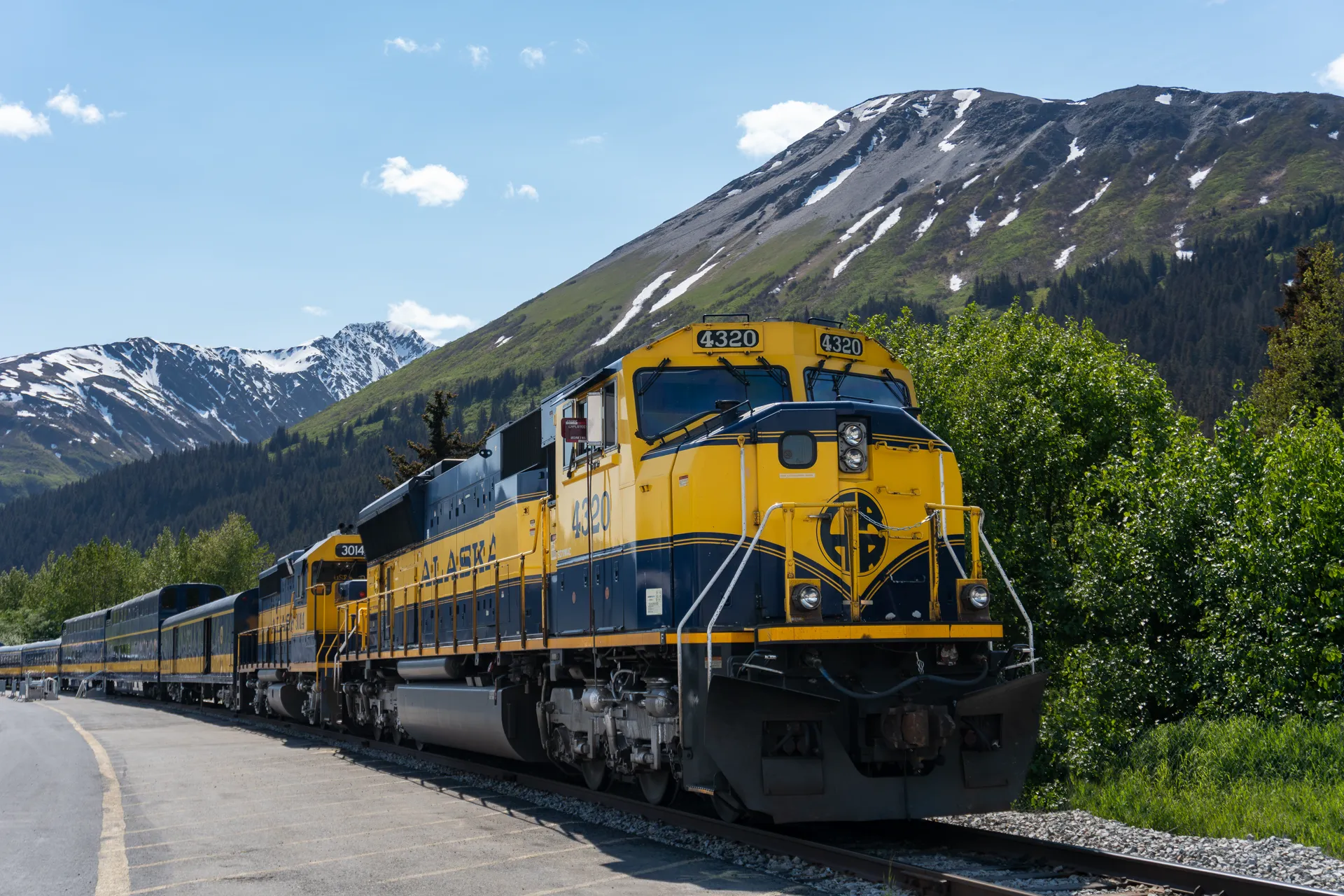 Alaska Railroad train through wilderness with snow-capped mountains